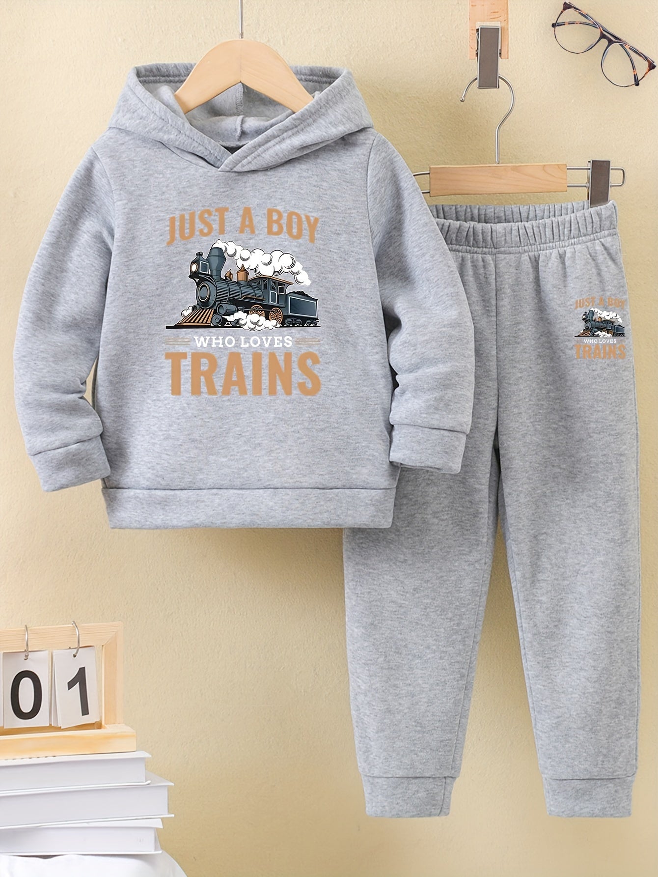 A Boy's Hooded Sweatshirt And Sports Pants With Train Pattern Print