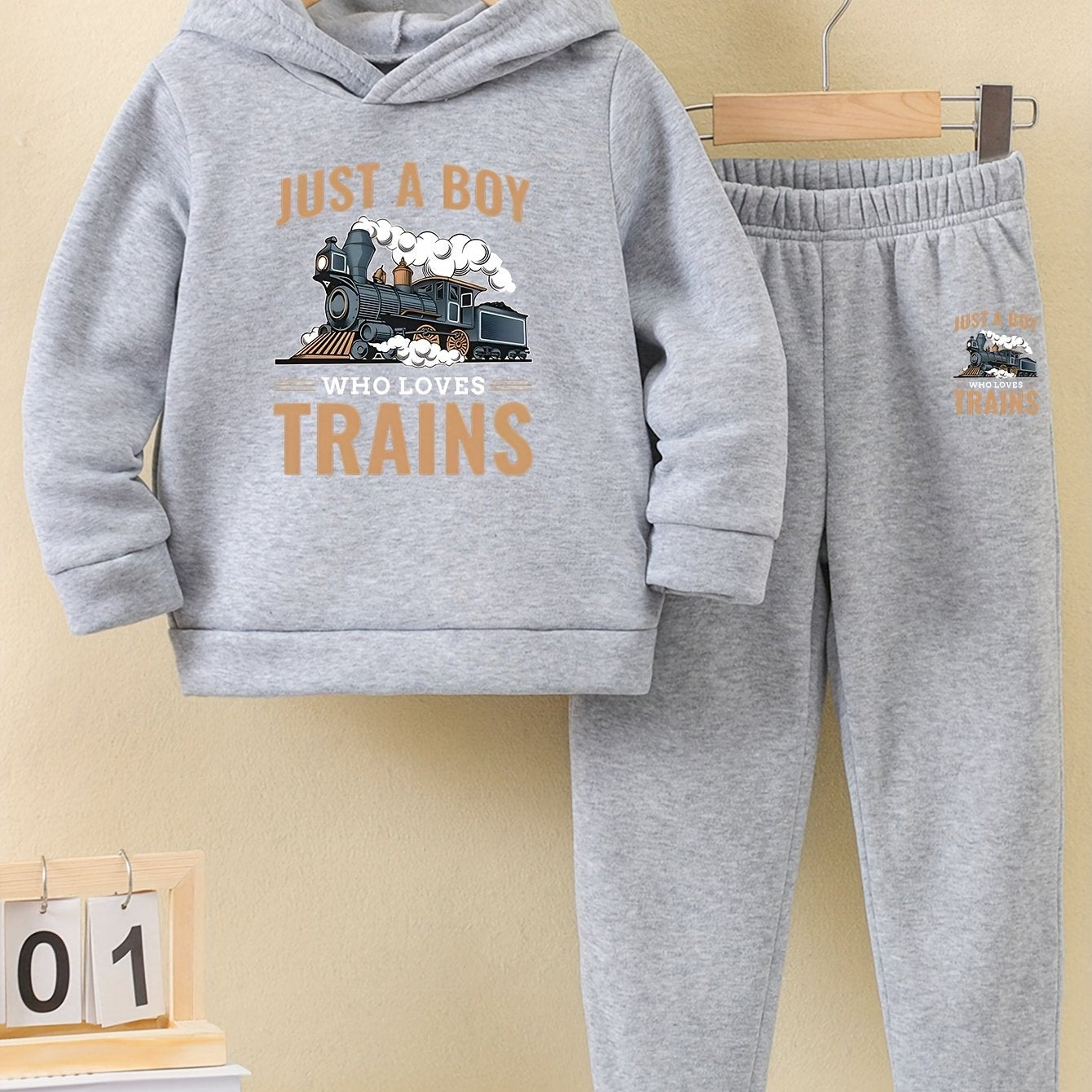 A Boy's Hooded Sweatshirt And Sports Pants With Train Pattern Print